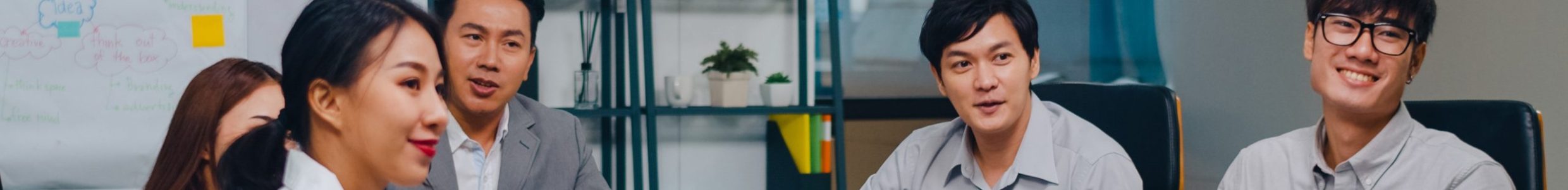 Millennial Asia businessmen and businesswomen having conference video call meeting brainstorming ideas about new project colleagues working together planning strategy enjoy teamwork in modern office.